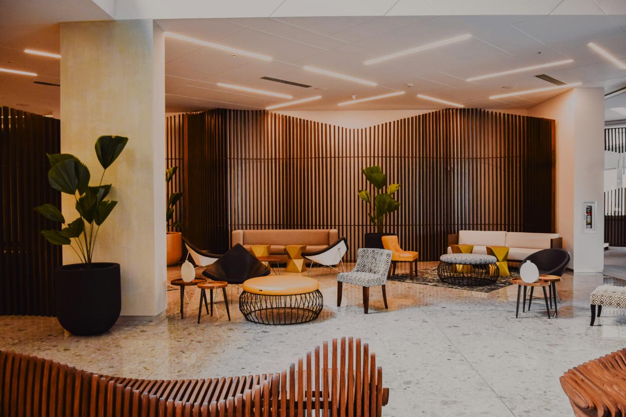 Lobi hotel modern dengan furnitur desainer dan dinding kayu