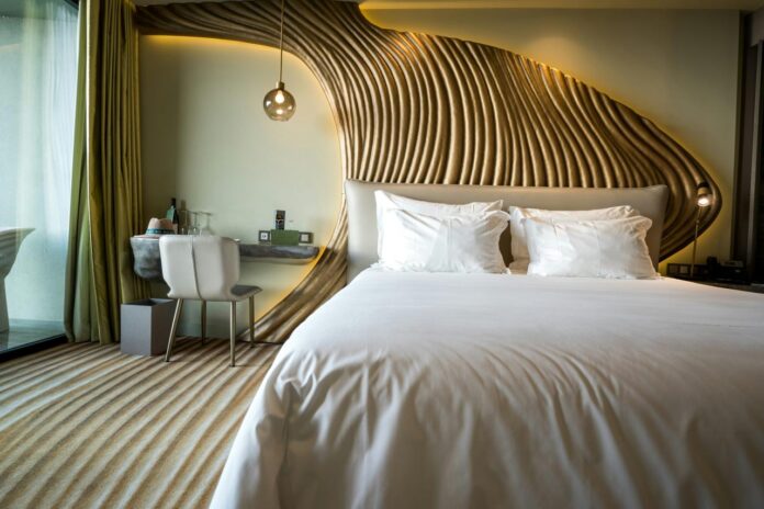 Kamar tidur dengan tempat tidur putih dan kepala tempat tidur kayu